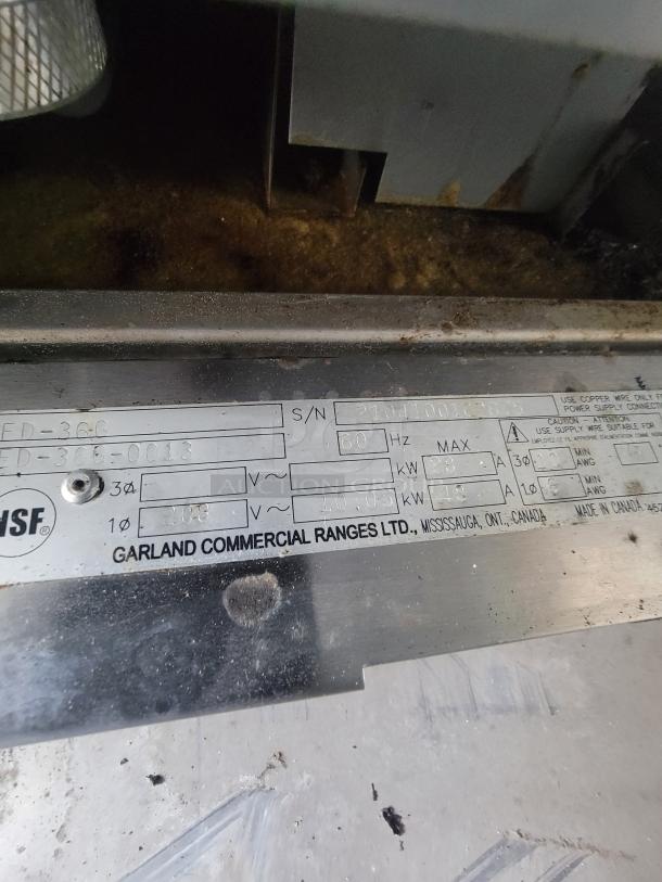 Label showing Garland Commercial Ranges Ltd. specifications on equipment, including serial number and power ratings. Needs cleaning.