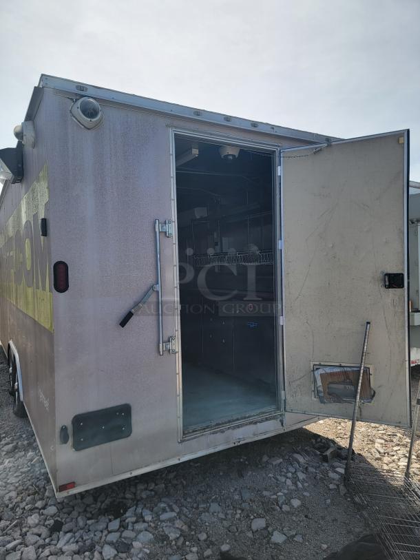 2019 Diamond Cargo 24' food trailer with open side door; features stainless steel walls, ventilation hood; needs cleaning.