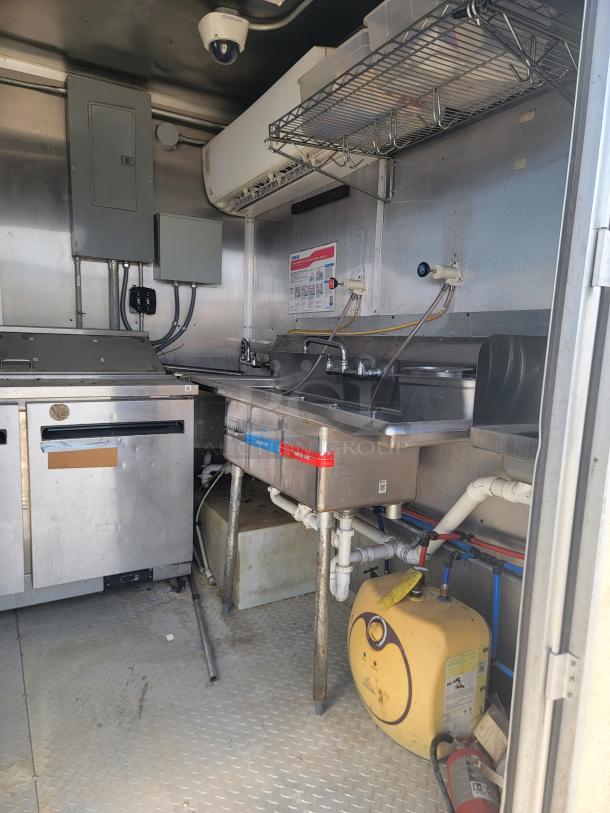 2019 Diamond Cargo 24' food trailer interior, featuring professional stainless steel walls, 3-compartment sink, and Arctic Air refrigeration. Needs cleaning.