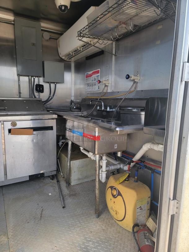 2019 Diamond Cargo 24' food trailer interior with stainless steel walls, 3-compartment sink, ventilation hood, visible wear.