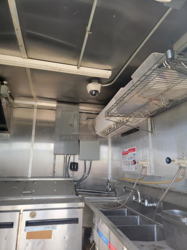 2019 Diamond Cargo 24' food trailer interior, featuring stainless steel walls, 3-compartment sink, and refrigeration units. Needs cleaning.