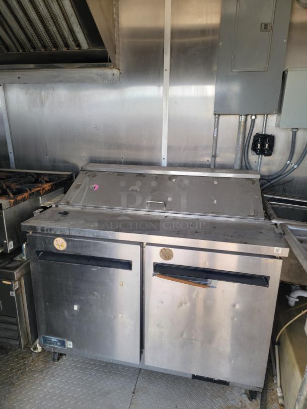 2019 Diamond Cargo 24' food trailer interior with stainless steel walls, Arctic Air refrigeration, and ventilation hood. Needs cleaning.