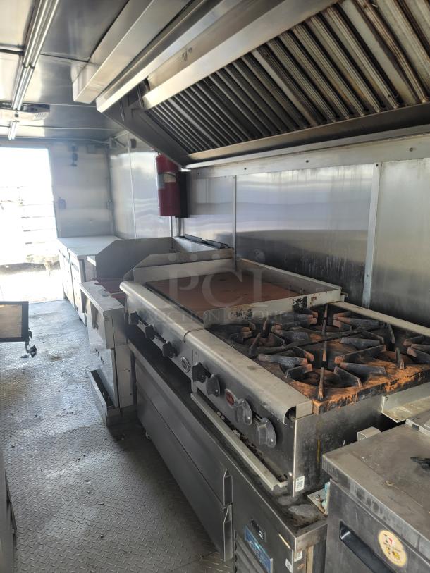 2019 Diamond Cargo 24' food trailer interior, stainless steel walls, ventilation hood, burners, needs cleaning.