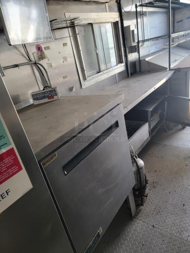 2019 Diamond Cargo 24' food trailer interior with stainless steel walls, ventilation hood, Arctic Air refrigeration, needs cleaning.