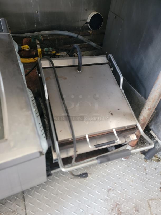 Waring commercial panini press with stainless steel base in a 2019 Diamond Cargo food trailer. Needs cleaning.