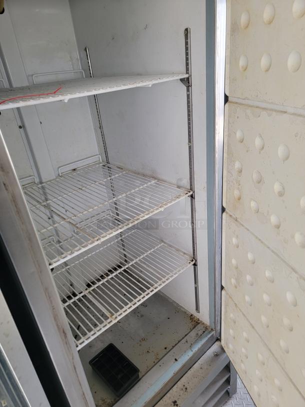 Interior view of a 2019 Diamond Cargo food trailer fridge; shelves show dirt, needs cleaning; spacious with adjustable racks.