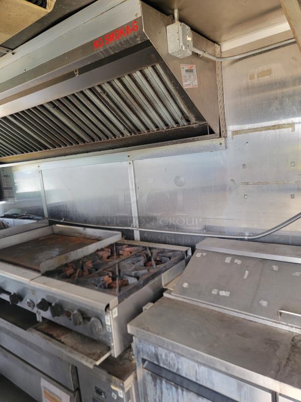 2019 Diamond Cargo 8.5x24 mobile kitchen interior with griddle, dual fryers, stainless exhaust hood, needs cleaning.