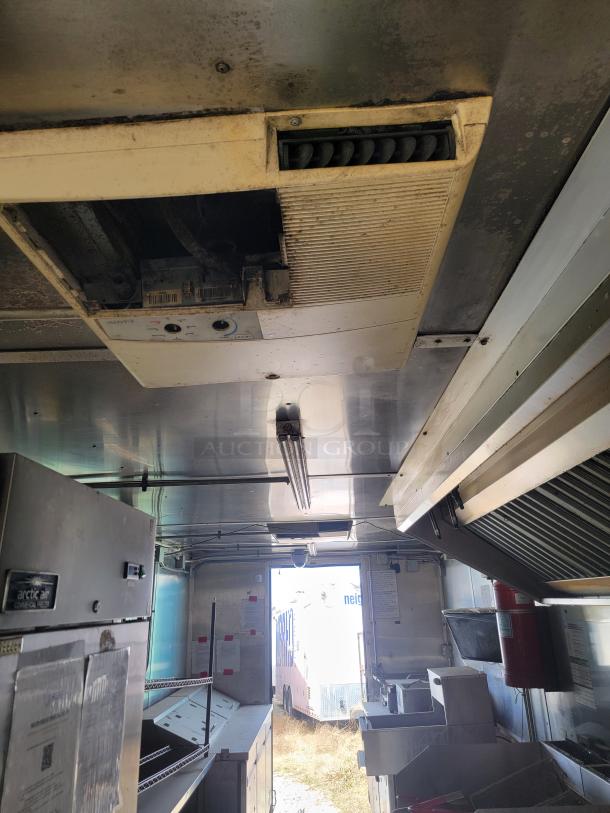 2019 Diamond Cargo 8.5x24 mobile kitchen interior, featuring Arctic Air fridge, dual fryers, griddle, exhaust hood. Needs cleaning.