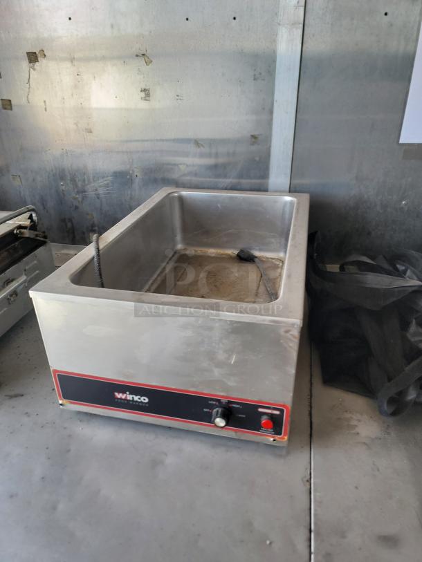 Winco food warmer, stainless steel, model with temperature control knob, visibly dusty, needs cleaning.