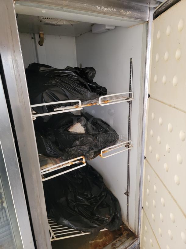 Interior view of a commercial refrigeration unit showing shelves with black bags, needs cleaning. Equipped for mobile kitchen.