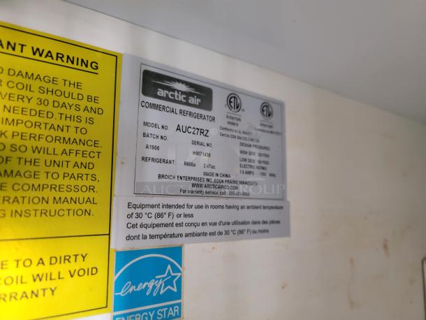 Arctic Air commercial refrigerator model AUC27R, label with specs and energy efficiency sticker, part of mobile kitchen setup.