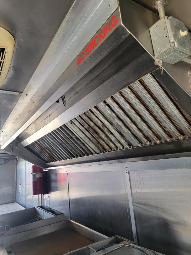 2019 Diamond Cargo mobile kitchen interior with vent hood, "No Smoking" sign, equipment setup, and stainless steel surfaces.