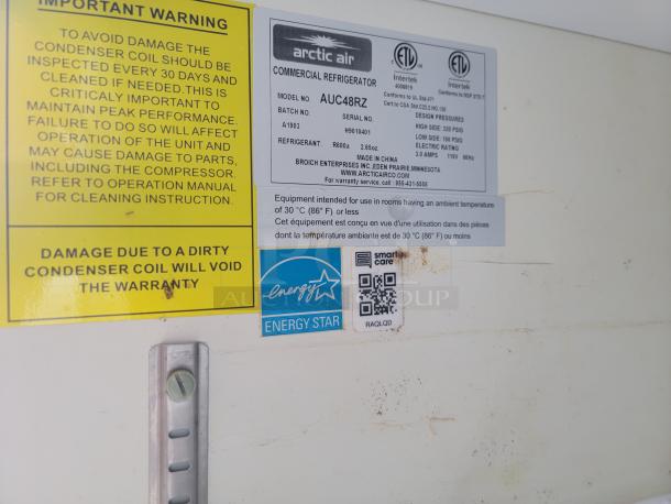 Safety and warranty labels on Arctic Air refrigerator model AUC48RZ inside 2019 Diamond Cargo 24' mobile kitchen.