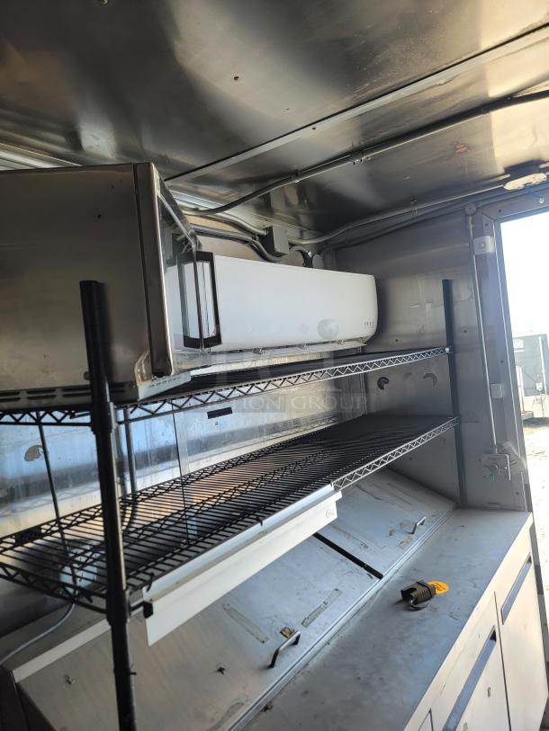 2019 Diamond Cargo 24' mobile kitchen interior with shelving, Pioneer AC unit, and industrial stainless steel surfaces.