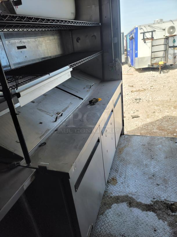 2019 Diamond Cargo 24' mobile kitchen interior with shelving, Arctic Air refrigeration, and stainless steel counters.