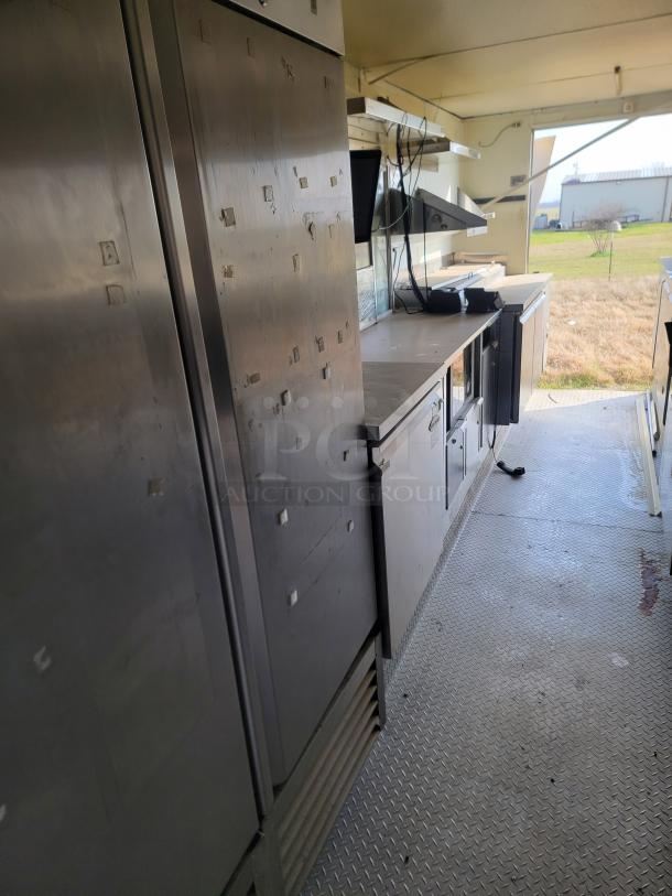 2019 Diamond Cargo 24' mobile kitchen interior with Serv-Ware refrigeration, stainless steel surfaces, needs minor repairs.