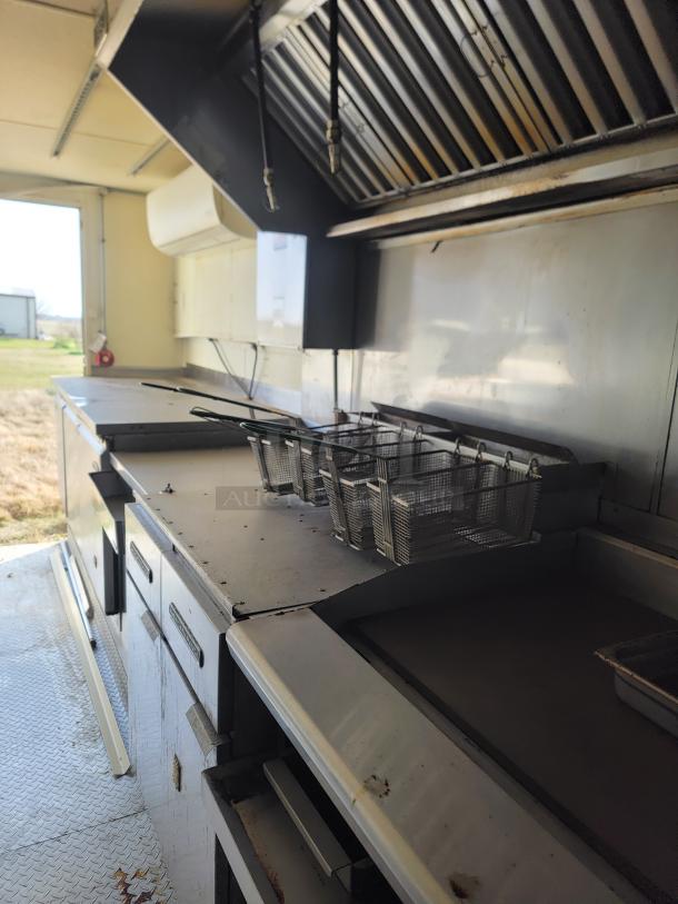 2019 Diamond Cargo 24' mobile kitchen interior with professional Serv-Ware and Dukers equipment, showing fryer and exhaust hood.