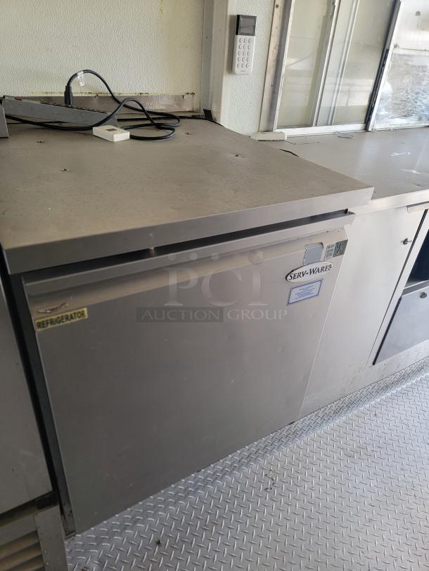 2019 Diamond Cargo 24' mobile kitchen interior with Serv-Ware refrigerator. Features stainless steel surface, keypad, minor wear.