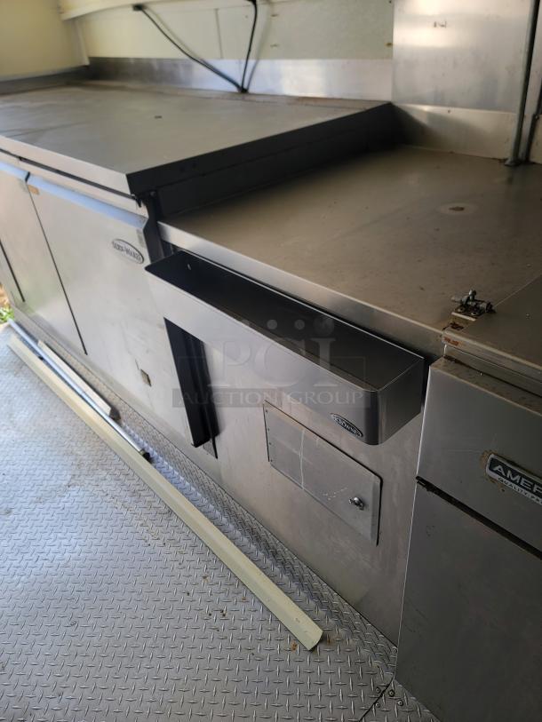 2019 Diamond Cargo 24' mobile kitchen interior with Serv-Ware equipment. Stainless steel surfaces, minor wear visible.