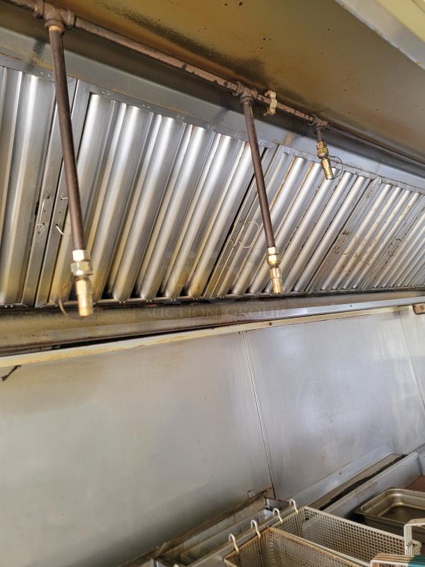 Interior of 2019 Diamond Cargo 24' mobile kitchen showing exhaust hood and fryer baskets, needs cleaning and minor exterior repair.