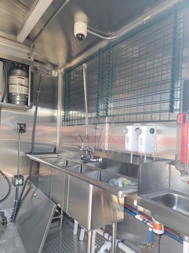 Rock Solid Cargo 28' mobile kitchen interior, featuring stainless steel triple sink, wiring, water system, and security camera.