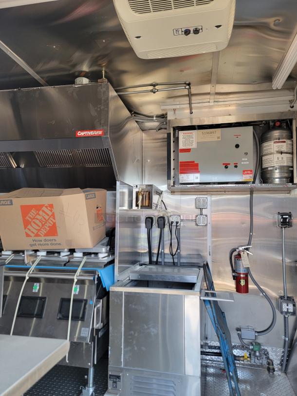 Interior of a 2022 Rock Solid Cargo 28' mobile kitchen, showing commercial-grade appliances, electrical systems, and safety equipment.