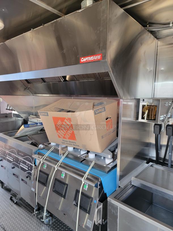 2022 Rock Solid Cargo 28' mobile kitchen interior with stainless steel equipment, CAPTIVEAIRE vent hood, and commercial appliances.