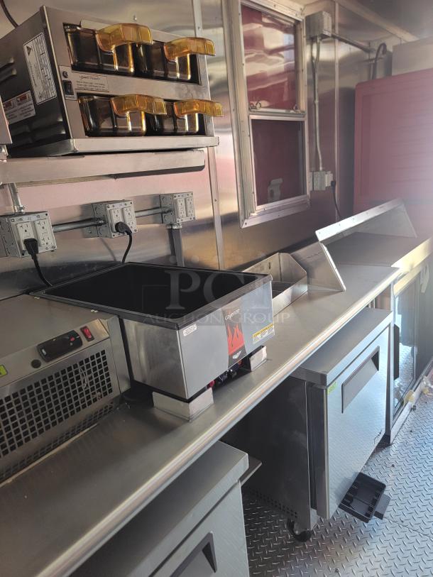 2022 Rock Solid Cargo 28' mobile kitchen interior with commercial appliances, triple-axle, high-capacity design for franchise use.