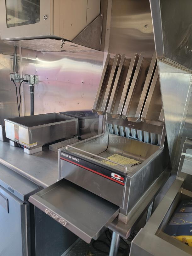 2022 Rock Solid Cargo 28' mobile kitchen interior showing stainless steel fry warmer labeled "Crisp N' Hold," and fry station.