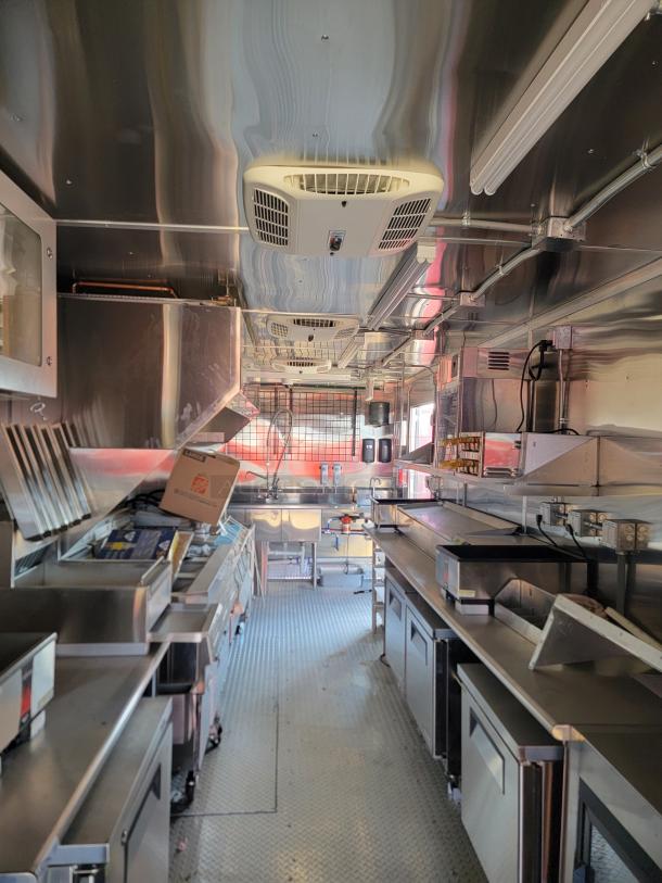 2022 Rock Solid Cargo 28' mobile kitchen trailer interior, showing stainless steel counters, commercial appliances, and ventilation.
