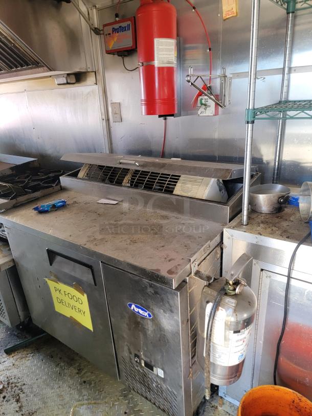 2019 Peach Cargo 24' mobile kitchen interior, featuring stainless equipment, fire extinguisher, ProTex II system, PK Food Delivery label.