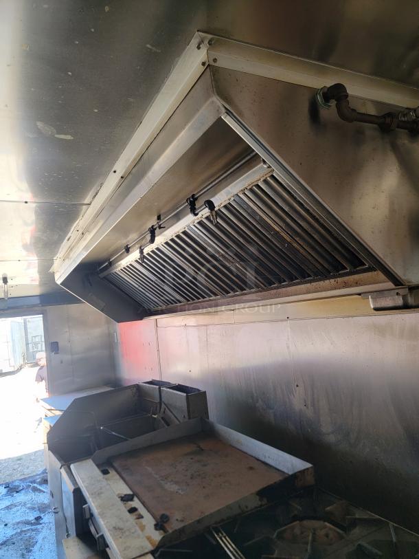 2019 Peach Cargo 24' mobile kitchen interior showing stainless steel cooking area and ventilation hood.