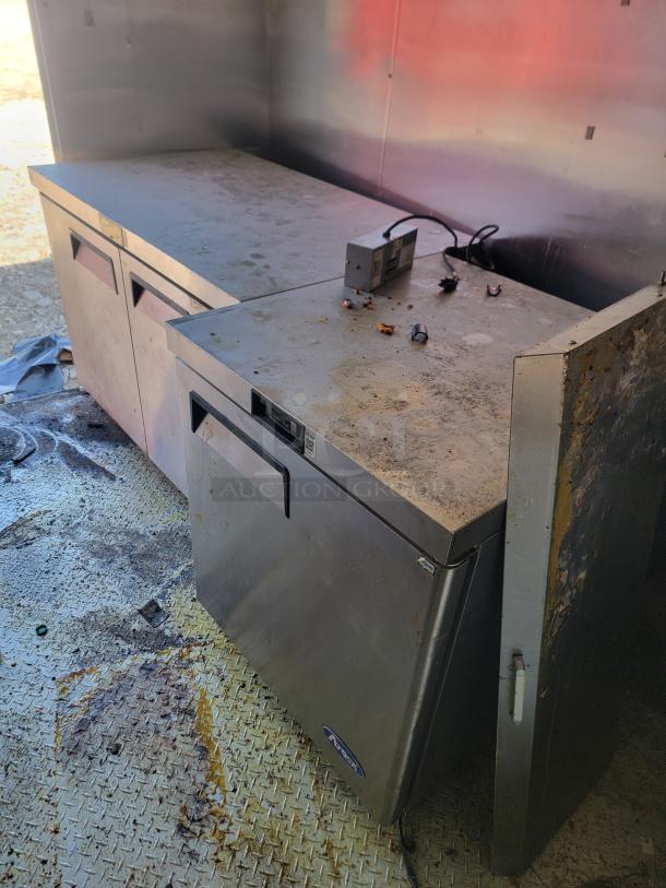 2019 Peach Cargo 24' mobile kitchen interior with high-capacity stainless steel workstations. Some wear visible. Ideal for food business expansion.