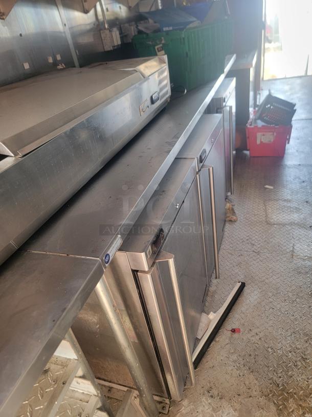 2021 Titanium Cargo 28' Mobile Kitchen interior, featuring stainless steel counters, Garland grill, and refrigeration units.