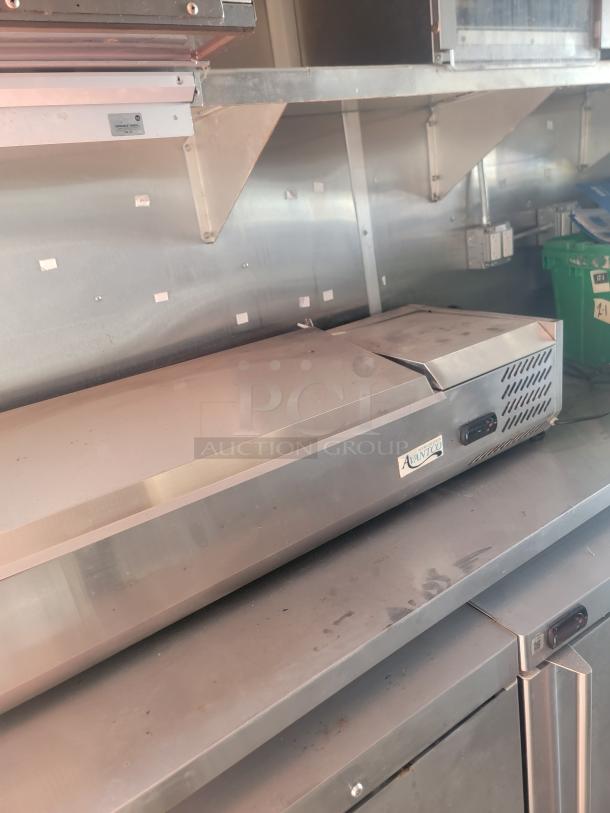 Stainless steel countertop with Avantco label, part of a mobile kitchen's high-grade equipment setup.