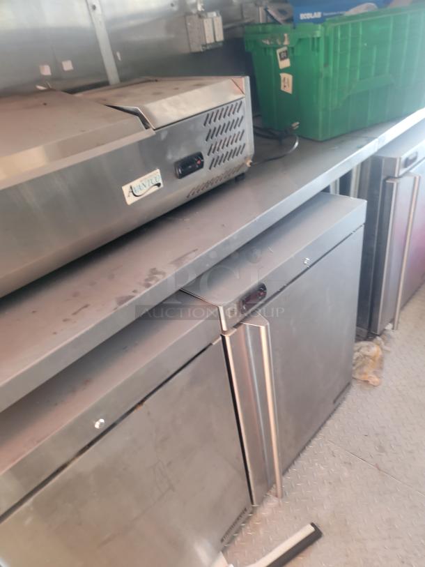 Interior view of a 2021 Titanium Cargo 28’ Mobile Kitchen with stainless steel commercial equipment, including Avantco appliance.