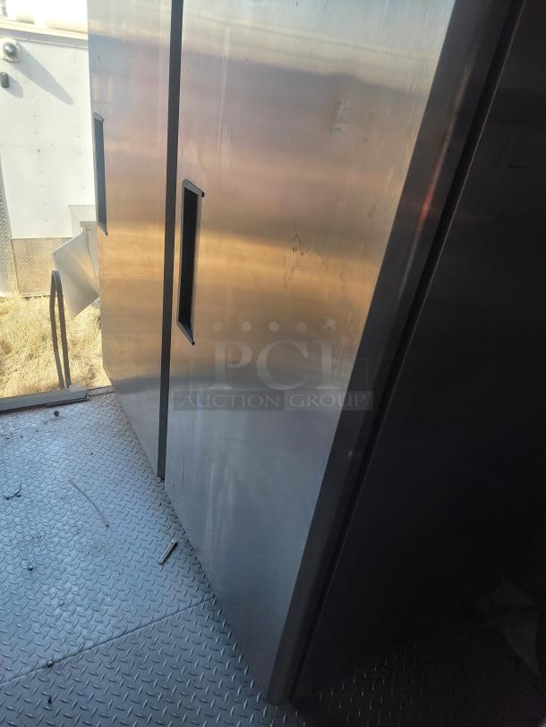 Interior of a 2021 Titanium Cargo 28' Mobile Kitchen, showing metal surfaces and durable flooring.