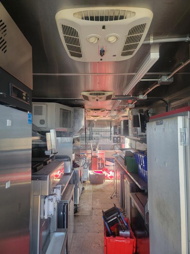 2021 Titanium Cargo 28' mobile kitchen interior with Garland grills, Henny Penny fryers, Menumaster ovens, and triple sinks.
