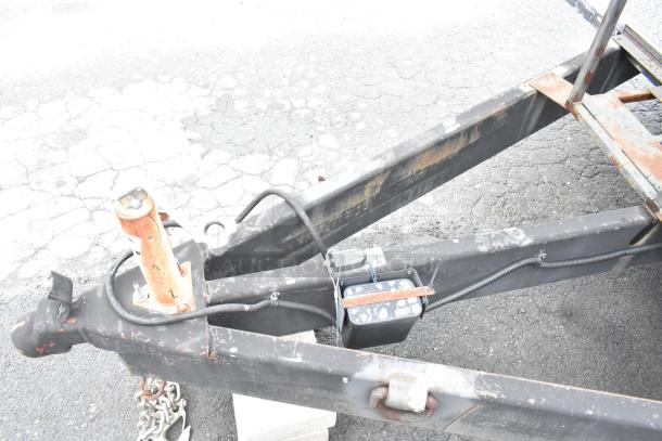 Close-up of the hitch and frame of a 2021 Rock Solid Cargo 24' mobile kitchen trailer. Rust and wear are visible.