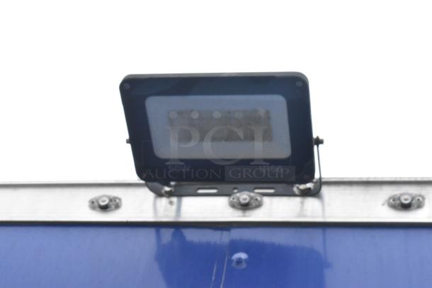 Outdoor LED light with 50W, IP66 rating, mounted on a blue surface. Suitable for commercial use.