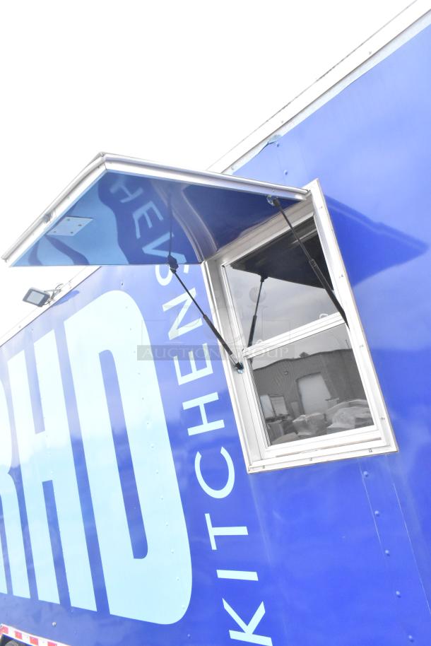 Blue 2021 Rock Solid Cargo 24' mobile kitchen trailer with serving window and overhead awning. Brand new, unused condition.
