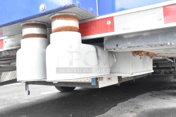 Underside of a brand new 2021 Rock Solid Cargo mobile kitchen trailer, featuring exhaust system components.