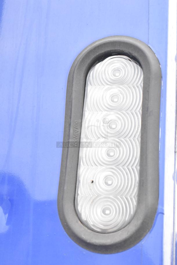 Close-up of blue 2021 Rock Solid Cargo trailer with a TedNiQ Inc. round LED light detail.