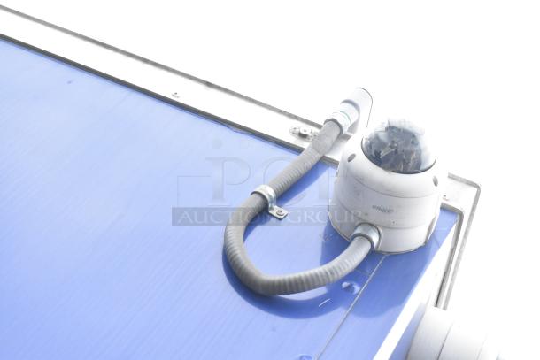 Blue exterior of 2021 Rock Solid Cargo 24' trailer with attached gray cables. New, for fast food setup.