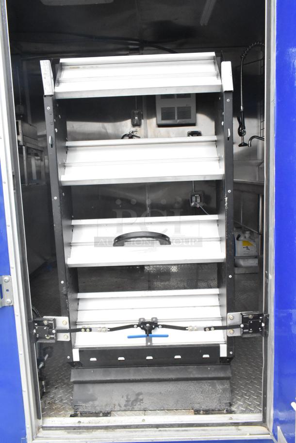 2021 Rock Solid Cargo 24' fast food trailer interior, featuring industrial shelves, sinks, and CaptiveAire grease hood, ready for use.