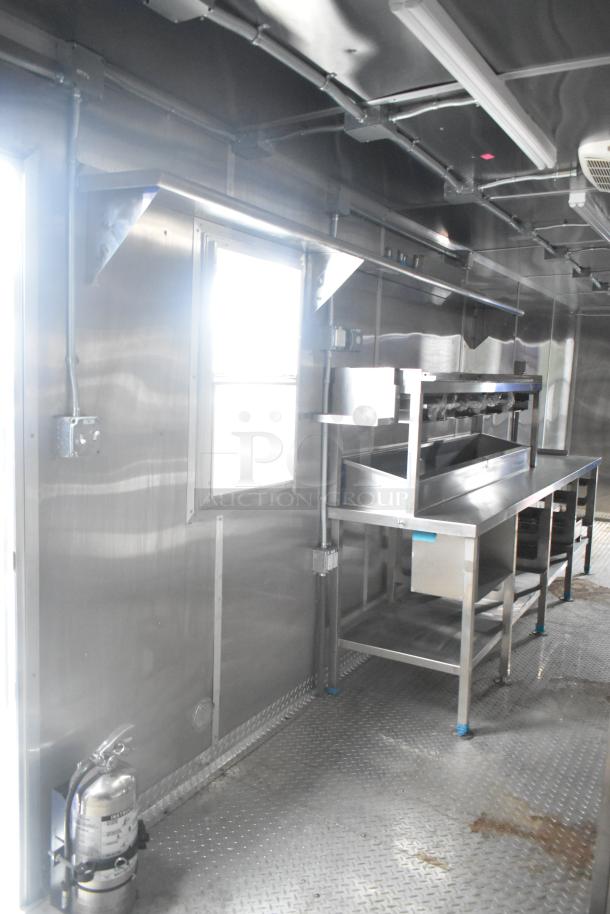 Brand new 2021 Rock Solid Cargo 24' mobile kitchen interior with stainless steel fixtures, commercial appliances, and CaptiveAire grease hood.