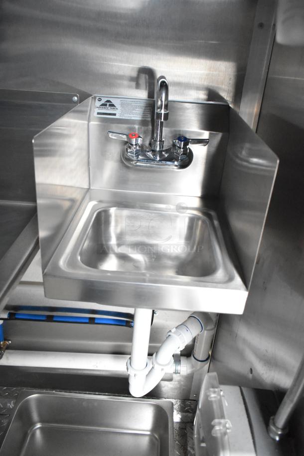 Stainless steel sink with faucet in new Rock Solid Cargo mobile kitchen trailer, featuring commercial-grade equipment.