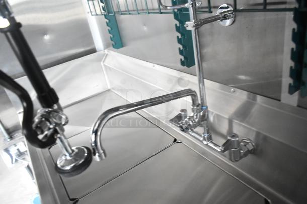 Brand new 2021 Rock Solid Cargo fast food trailer sink setup, featuring shiny faucet fixtures and stainless steel surfaces.