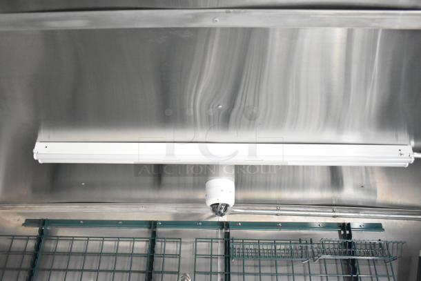 Interior view of a new Rock Solid Cargo 24' mobile kitchen trailer. Stainless steel walls, lighting fixture, and surveillance camera visible.