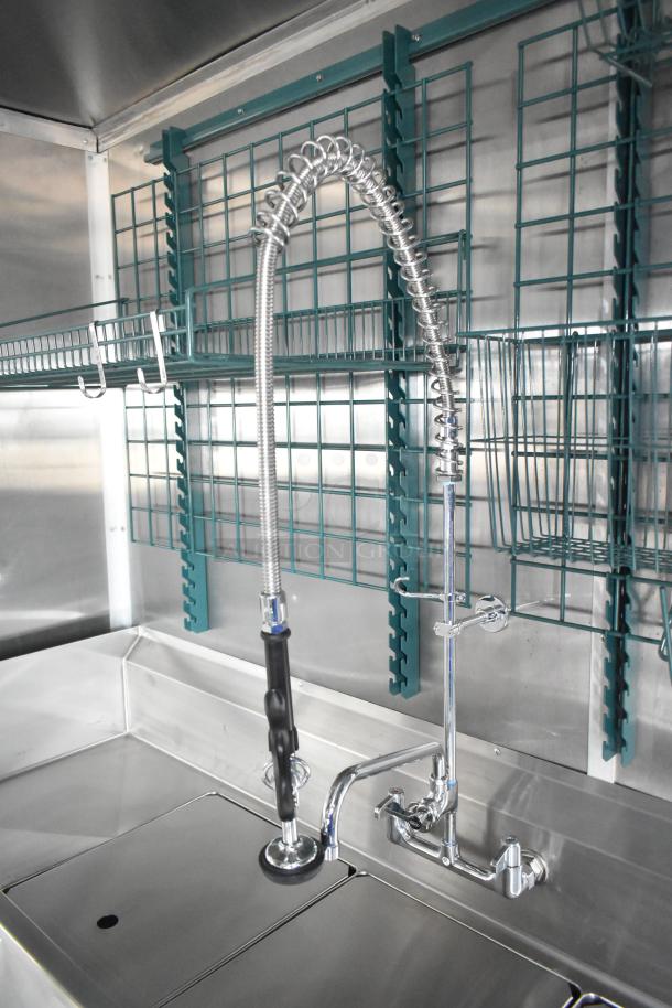 Rock Solid Cargo mobile kitchen with stainless steel sink, chrome faucet, and shelf storage. Fully equipped and brand new.